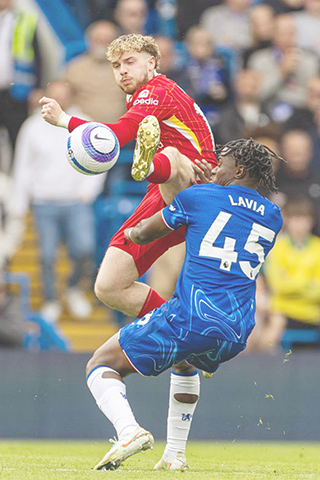 ◎ 五月四日,利物浦隊艾利洛(上)與車路士隊球員拉維亞拼搶。(新華社發)